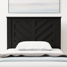 a bed with a black headboard and white sheets