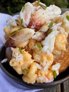 a bowl filled with macaroni and cheese on top of a wooden table