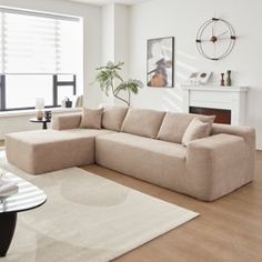 a living room filled with furniture and a fire place next to a large white wall