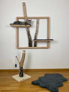 a cat sitting on top of a wooden shelf next to a tree