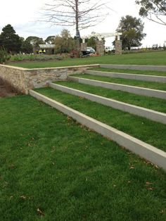 some steps in the grass near a stone wall