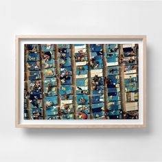 a white framed photo hanging on the wall next to a shelf filled with blue boxes