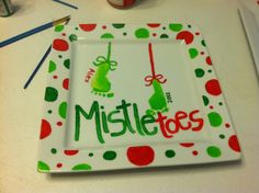 a plate with the words mistle toes on it next to pencils and markers