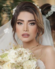 a woman in a wedding dress holding a bridal bouquet and looking at the camera