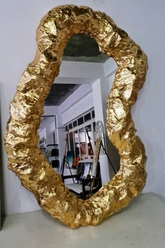 a large gold mirror sitting on top of a table