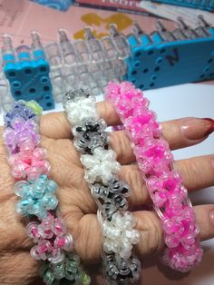 a woman's hand holding several bracelets made out of plastic bead beads