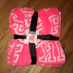 two pink and white towels sitting on top of a wooden floor next to each other