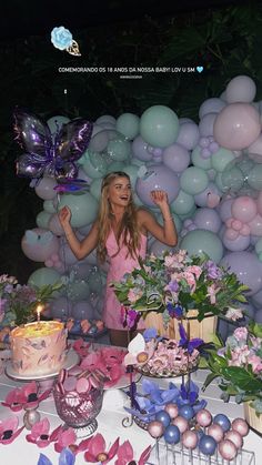 a woman standing in front of a table filled with balloons