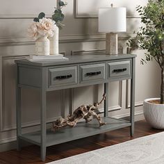 a dog laying on the floor next to a grey console table with two drawers and one drawer