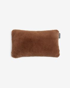 a brown pillow on a white background