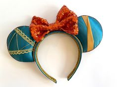 a blue and orange mouse ears with a red bow