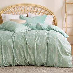 a bed with green comforters and pillows in a room