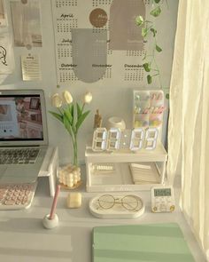 a laptop computer sitting on top of a desk next to a clock and other items