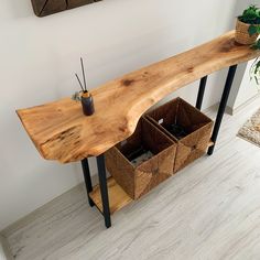 a wooden table sitting on top of a hard wood floor next to a potted plant