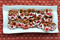 pretzels decorated with white and red sprinkles are on a plate