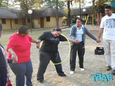 four people are playing with a hula hoop