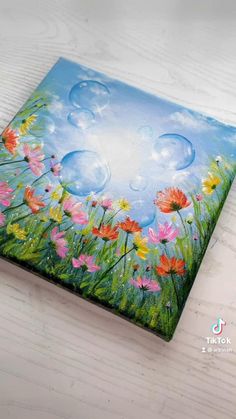 a painting of flowers and bubbles on a wooden surface