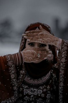 a woman with her hands on her face and wearing a veil over her head, covering her eyes