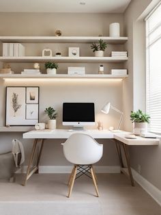 a desk with a computer and some plants on it