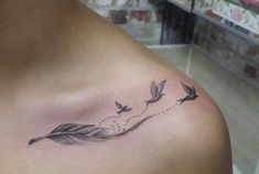 a woman with a tattoo on her shoulder and some birds flying away from the feather