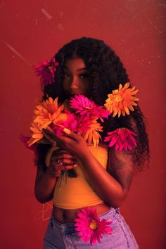 a woman is holding flowers in her hands