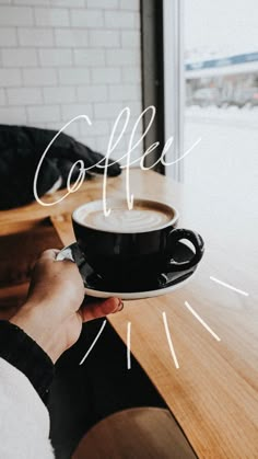 a person holding a cup of coffee with the word coffee written in white over it