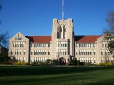 a large building with a clock tower in the middle of it's front yard