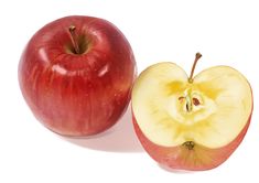 an apple cut in half and sitting next to it's core on a white background