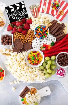 a table topped with lots of food and candy on top of a white platter