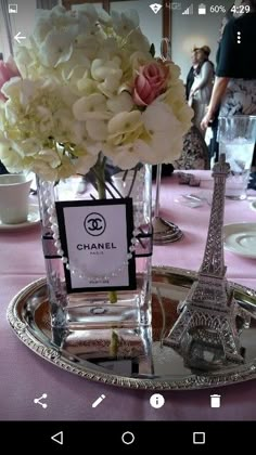 there is a vase with flowers in it on the table next to the eiffel tower