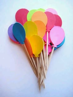 a bunch of colorful wooden paddles sitting next to each other on a white surface