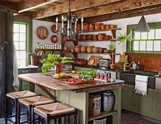 a kitchen with lots of pots and pans hanging from the ceiling over an island