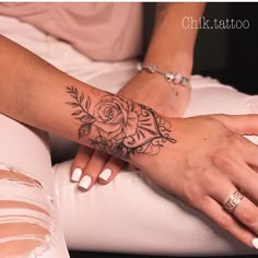 a woman's arm with a rose tattoo on it, sitting next to her legs