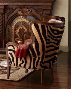 a zebra print chair sitting in front of a fire place