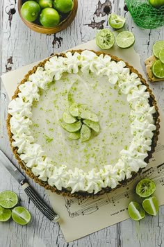 a lime pie with whipped cream and sliced limes