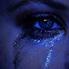 a woman's blue eyes are covered in white powder and glitter as she stares into the camera