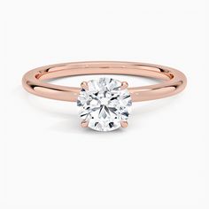 a rose gold engagement ring with a round cut diamond in the center, on a white background