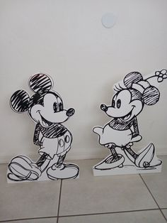 two drawings of mickey and minnie mouse standing next to each other in front of a wall