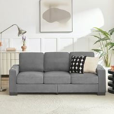 a living room with a gray couch and white rug