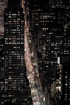 an aerial view of a city at night with lots of traffic and tall buildings lit up