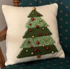 a knitted christmas tree pillow on a chair