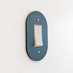 a blue light switch mounted to the side of a white wall next to a white wall