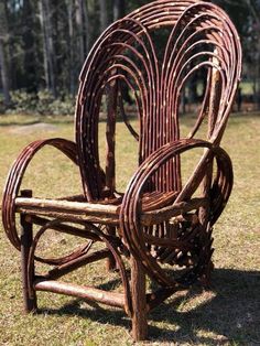 a chair made out of branches sitting in the grass