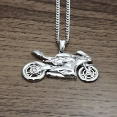 a silver necklace with a motorcycle on it