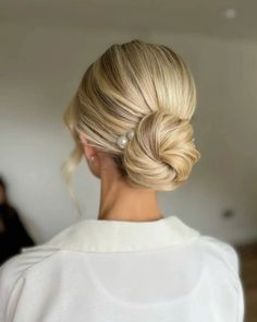 a woman with blonde hair in a low bun