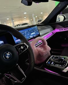 the interior of a car with purple lights and steering wheel, dashboard, and touch screen