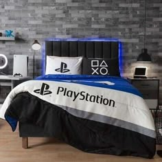 a bed room with a neatly made bed and a playstation logo on the comforter