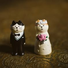 two small figurines of cats dressed in wedding attire