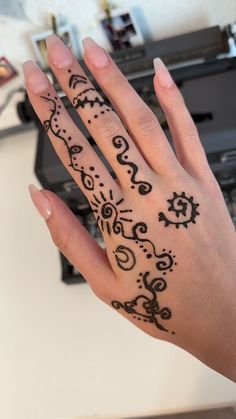 a woman's hand with henna tattoos on it