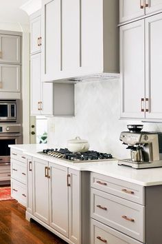 a kitchen with white cabinets and stainless steel appliances